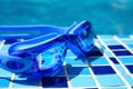 a blue swimming goggles on the side of a swimming pool Royalty Free Stock Photo