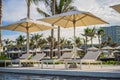 Blue swimming pool with beach lounger with parasol, sun deck on sea view for summer vacation Royalty Free Stock Photo