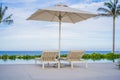 Blue swimming pool with beach lounger with parasol, sun deck on sea view for summer vacation Royalty Free Stock Photo