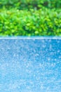 Blue swimming pool in the rain, blurred green garden backgrounds. Exterior tropical pool. Selective focus Royalty Free Stock Photo