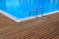 Blue swimming pool with teak wood flooring Royalty Free Stock Photo