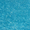 Blue swimming pool water with a tiled bottom. The tiles are arranged in a grid patter Royalty Free Stock Photo