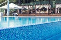 Blue swimming pool with wooden deck at hotel. Royalty Free Stock Photo