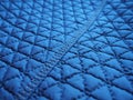 Blue synthetic quilted raincoat fabric close-up. Machine stitches are sewn in several directions to create an effect of Royalty Free Stock Photo