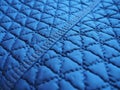 Blue synthetic quilted raincoat fabric close-up. Machine stitches are sewn in several directions to create an effect of Royalty Free Stock Photo