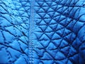 Blue synthetic quilted raincoat fabric close-up. Machine stitches are sewn in several directions to create an effect of Royalty Free Stock Photo