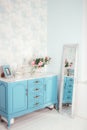 Blue table, a framed photo, flowers in a vase