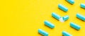 Blue tablets in capsules. One capsule is open. Yellow background. Copy space for text Royalty Free Stock Photo