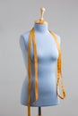 Blue tailor dummy with measuring tape alongside the wall. Royalty Free Stock Photo