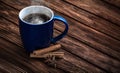 Blue tea cup on an old wooden surface. Old brown boards. Cinnamon sticks and anise near the cup. The concept of home warmth and Royalty Free Stock Photo