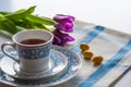 Cup of tea with purple spring tuplis and bright yellow chocolate eatser eggs Royalty Free Stock Photo