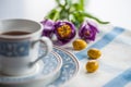 Cup of tea with purple spring tuplis and bright yellow chocolate eatser eggs Royalty Free Stock Photo