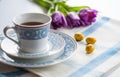 Cup of tea with purple spring tuplis and bright yellow chocolate eatser eggs Royalty Free Stock Photo