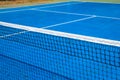 Blue tennis court with net, sport field photo. Lawn tennis on hard court. Sunny tennis court empty abstract photo Royalty Free Stock Photo