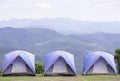 Blue tent lined 3 houses on the lawn background Mountains and sky Royalty Free Stock Photo