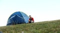Blue tent in the middle of the lawn. man in red suit sitting by the tent Royalty Free Stock Photo