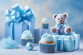 Blue theme baby boy cupcakes and baby favour gift boxes against blue background for baby shower or new born nursery greeting card