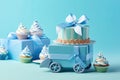 Blue theme baby boy cupcakes and baby favour gift boxes against blue background for baby shower or new born nursery greeting card