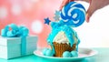 Blue novelty cupcake decorated with candy and large lollipops.