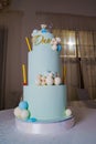 a blue three-tiered cake decorated with bear cub and caramel balls Royalty Free Stock Photo