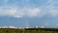 Blue thunderclouds and rainbow over city in spring Royalty Free Stock Photo