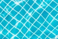 Blue tile on swimming pool bottom under clear water with sun light reflection. Travel, vacation concept Royalty Free Stock Photo