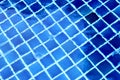 The blue tiles floor under the clear water in the swimming pool background. Royalty Free Stock Photo