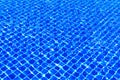 The blue tiles floor under the clear water in the swimming pool background, Swimming pool surface with floor mosaic tiles in blue Royalty Free Stock Photo