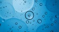 Blue-toned abstract image featuring numerous translucent liquid bubbles of