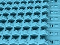 Blue toned abstract image of a large residential highrise building with geometric rows of balconies