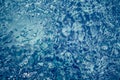 Blue toned whirling water background with bubbles and ripples in swimming pool Royalty Free Stock Photo