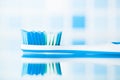 Blue toothbrush in a bathroom with reflection