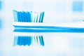 Blue toothbrush in a bathroom with reflection