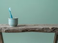 Blue Toothbrush in Ceramic Cup on Rustic Wooden Table - Mint Background Royalty Free Stock Photo