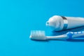 Blue toothbrush with silicone bristles and a tube of toothpaste on a blue background. Royalty Free Stock Photo