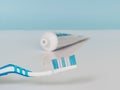 Blue toothbrush and toothpaste on a white blue background. The concept of daily dental care Royalty Free Stock Photo