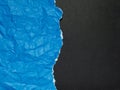 Blue torn and crumpled paper on a black background Royalty Free Stock Photo