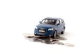 Kiev, Ukraine - February 2, 2020.Blue toy iron car with coins on a white background. concept of earnings, income and high cost