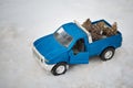 Blue toy pickup truck in winter forest on the road with open door. Carrying fir cones in the back of a car body Royalty Free Stock Photo