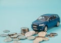 Blue toy SUV car crashed into a stack of money, car insurance concept Royalty Free Stock Photo