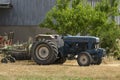 Blue tractor close up on a mowed field in the sunny day Royalty Free Stock Photo