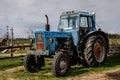 Blue tractor on a farm. Cloudy sky on background Royalty Free Stock Photo