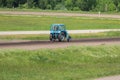 Blue tractor in the field. Heavy machinery. Repair of running track on hippodrome. Trimming lawn. Tractor in countryside. Royalty Free Stock Photo