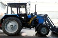 blue tractor with large wheels and front bucket Royalty Free Stock Photo