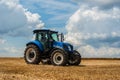 Blue tractor New Holland in motion at demonstration field site at agro exhibition Tractor working on the farm, modern agricultural Royalty Free Stock Photo