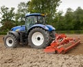 Blue Tractor Pulling Power Harrow Royalty Free Stock Photo