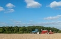 A blue tractor with a seed drill in a ploughed field Royalty Free Stock Photo