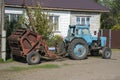 Blue tractor with a trailer for collecting straw in bundles. Royalty Free Stock Photo