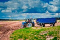 Blue tractor with trailer. Equipment for agriculture. Successful farming