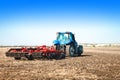 Blue tractor working in an open field Royalty Free Stock Photo